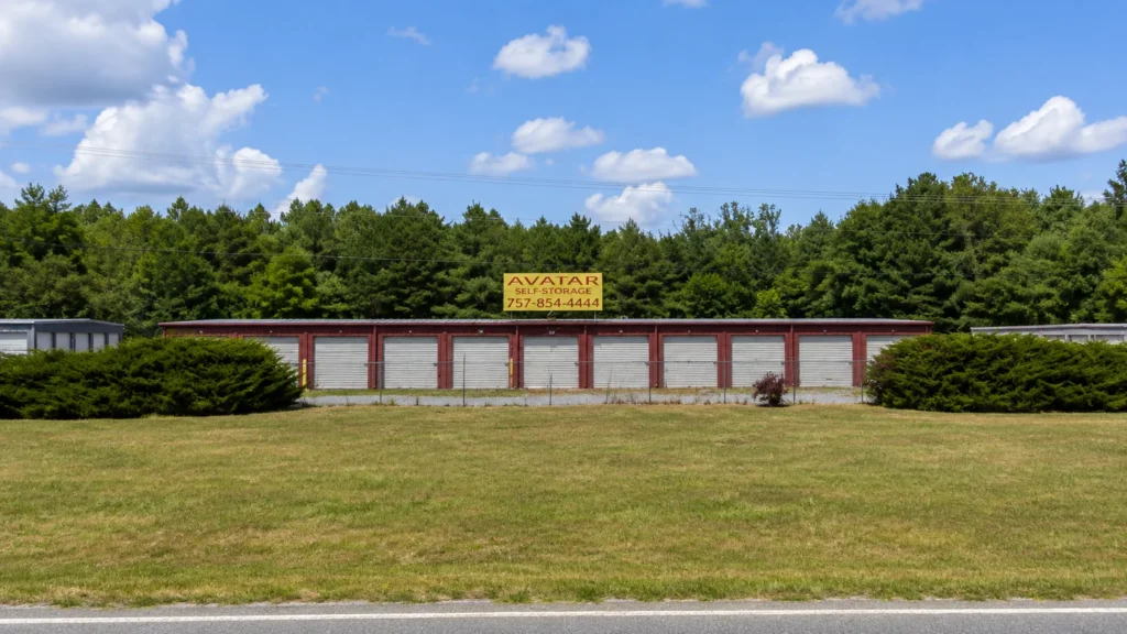 Exterior of the Avatar Self Storage facility in Denton, MD, with a covered loading canopy and landscaped entrance